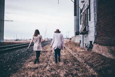 Two people walk along the railway's photo
